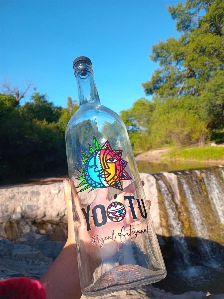 Botella de Yoó Tu frente a una cascada