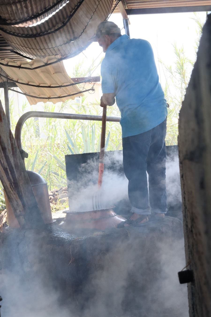 Maestro mezcalero entre el vapor del alambique